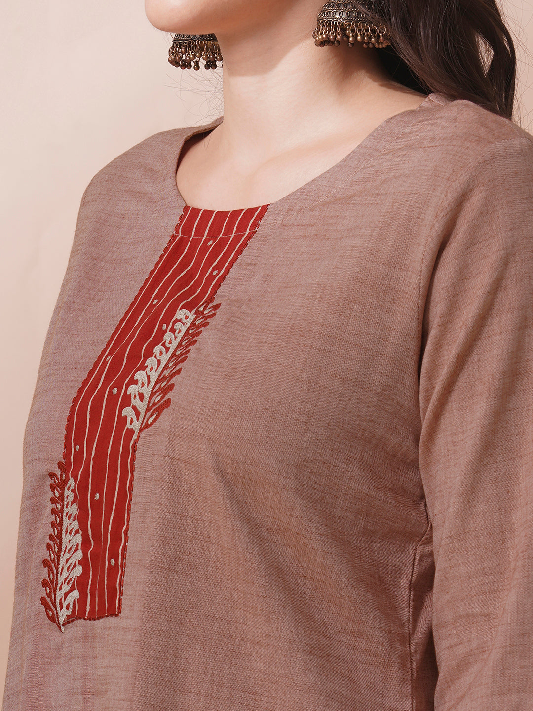 The kurta suit set features a machine embroidered and trim detail.