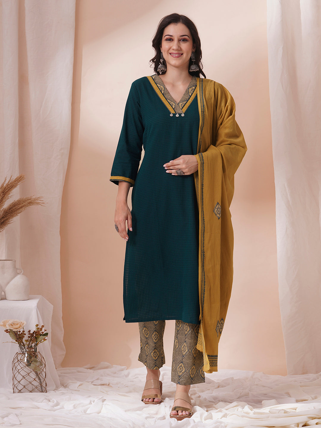 Forest green straight fit kurta suit set crafted with self dobby cotton fabric paired with geometric print bottom and applique dupatta.