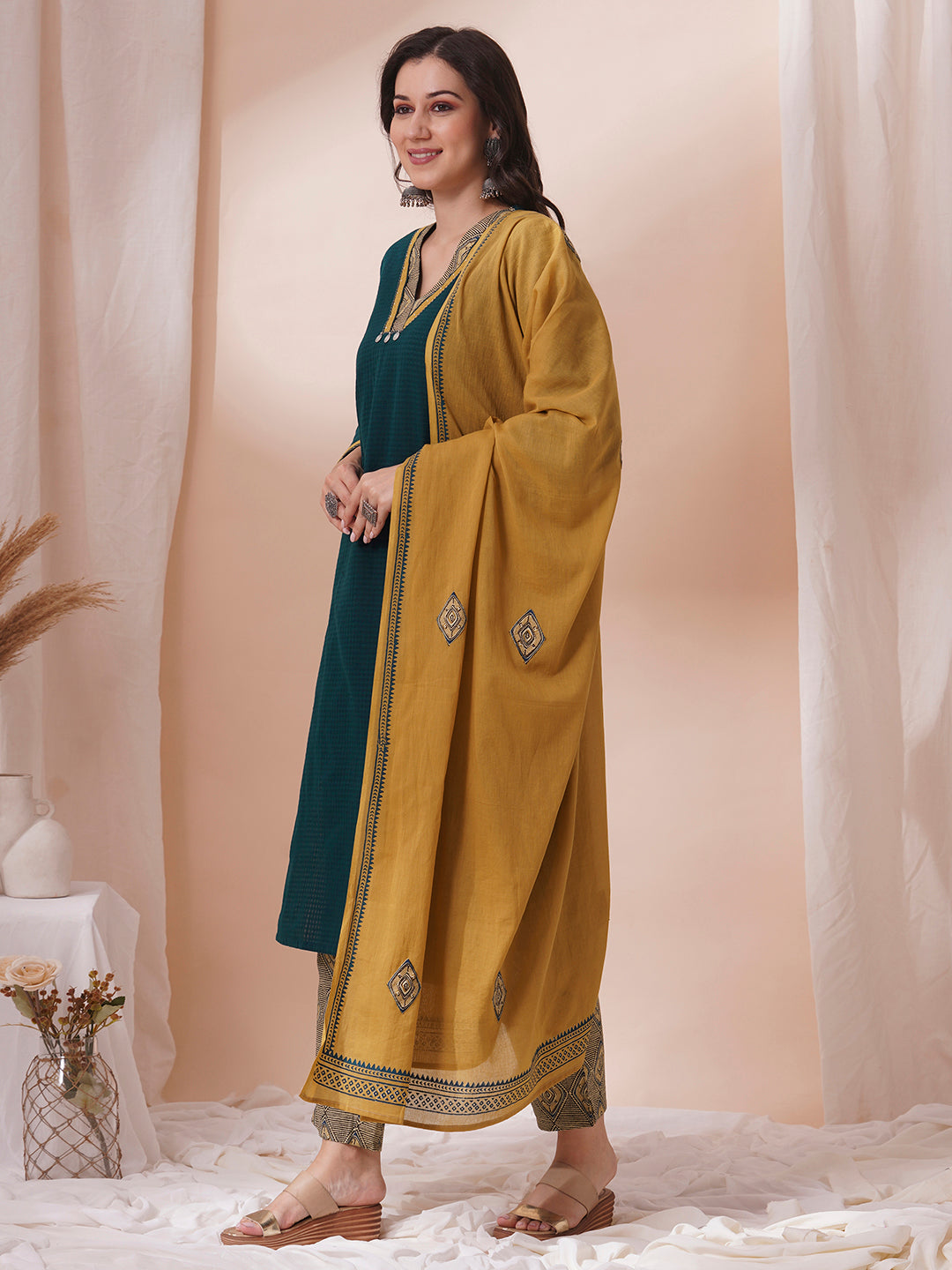 Forest green straight fit kurta suit set crafted with self dobby cotton fabric paired with geometric print bottom and applique dupatta.