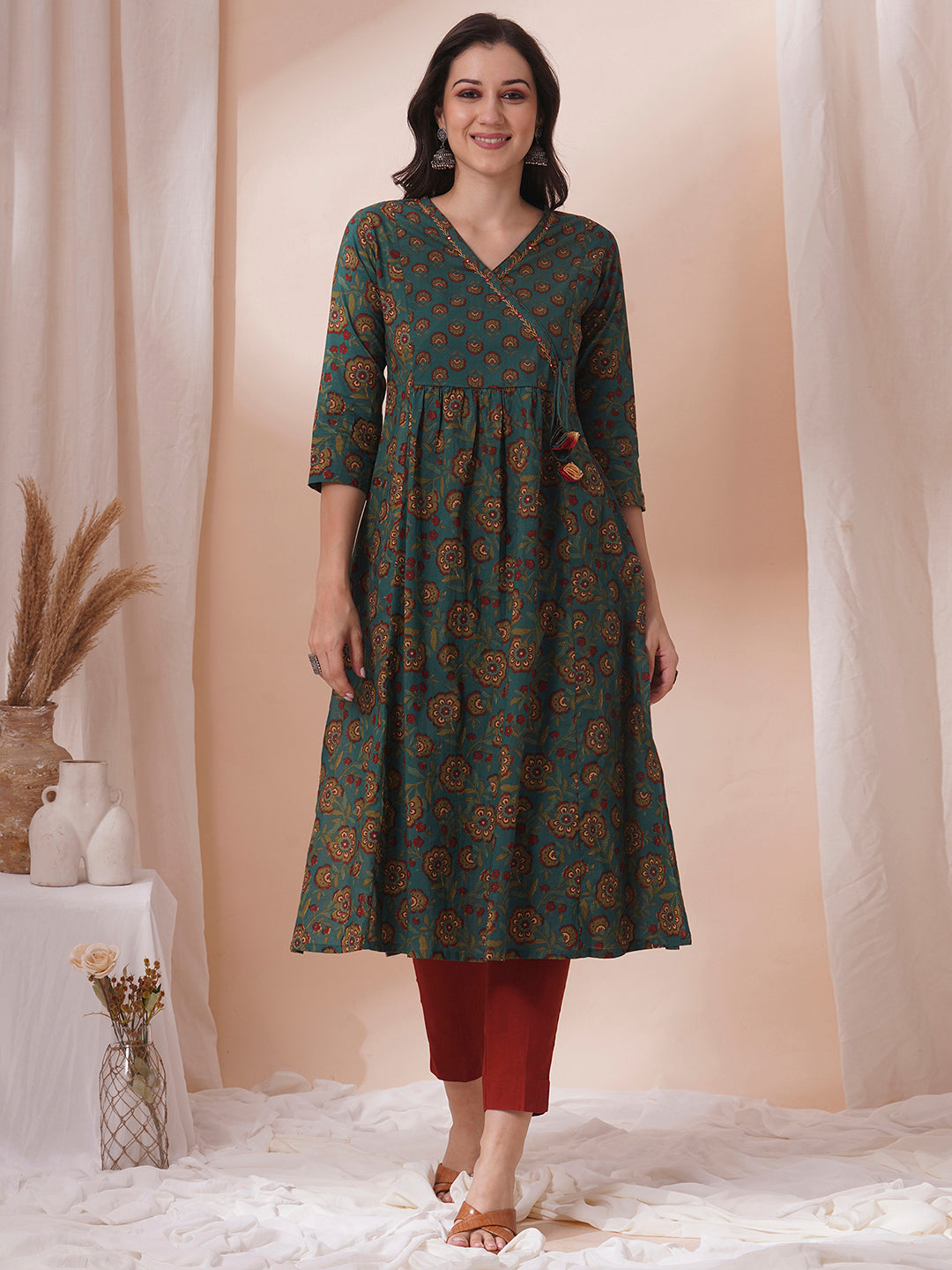 Fit and flare cotton print kurta with hand embroidery, overlap yoke and fabric tassels.