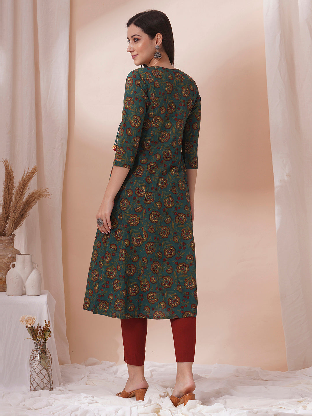 Fit and flare cotton print kurta with hand embroidery, overlap yoke and fabric tassels.