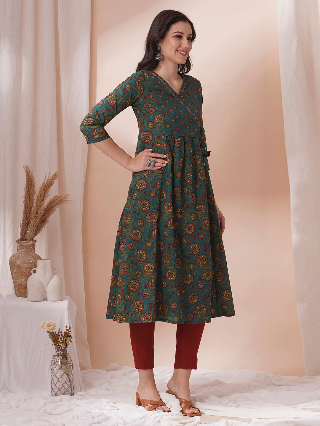 Fit and flare cotton print kurta with hand embroidery, overlap yoke and fabric tassels.