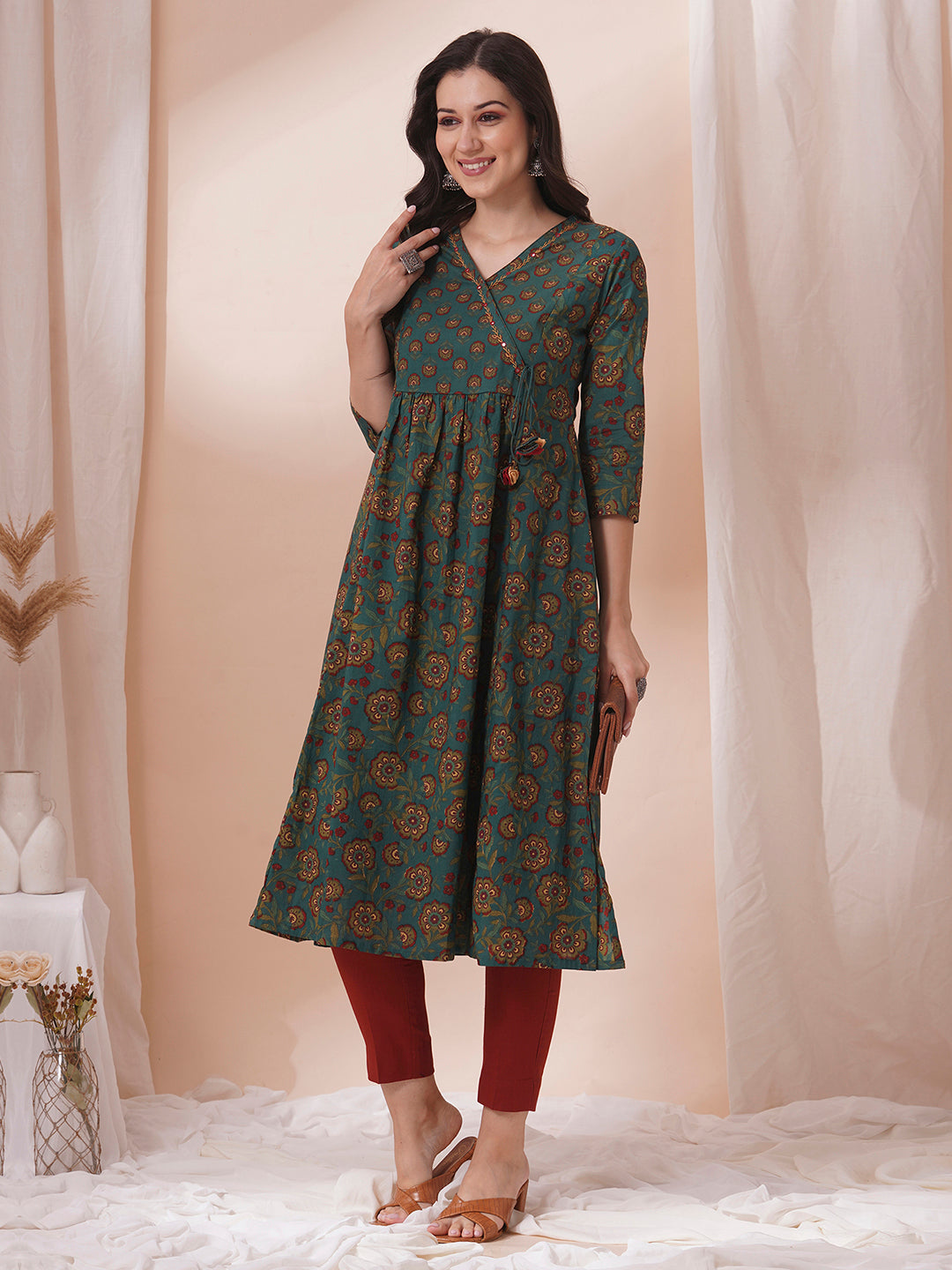 Fit and flare cotton print kurta with hand embroidery, overlap yoke and fabric tassels.
