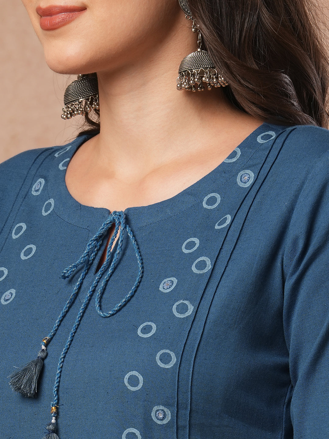 A-line cotton flex kurta with mirror work and attached thread tassels.