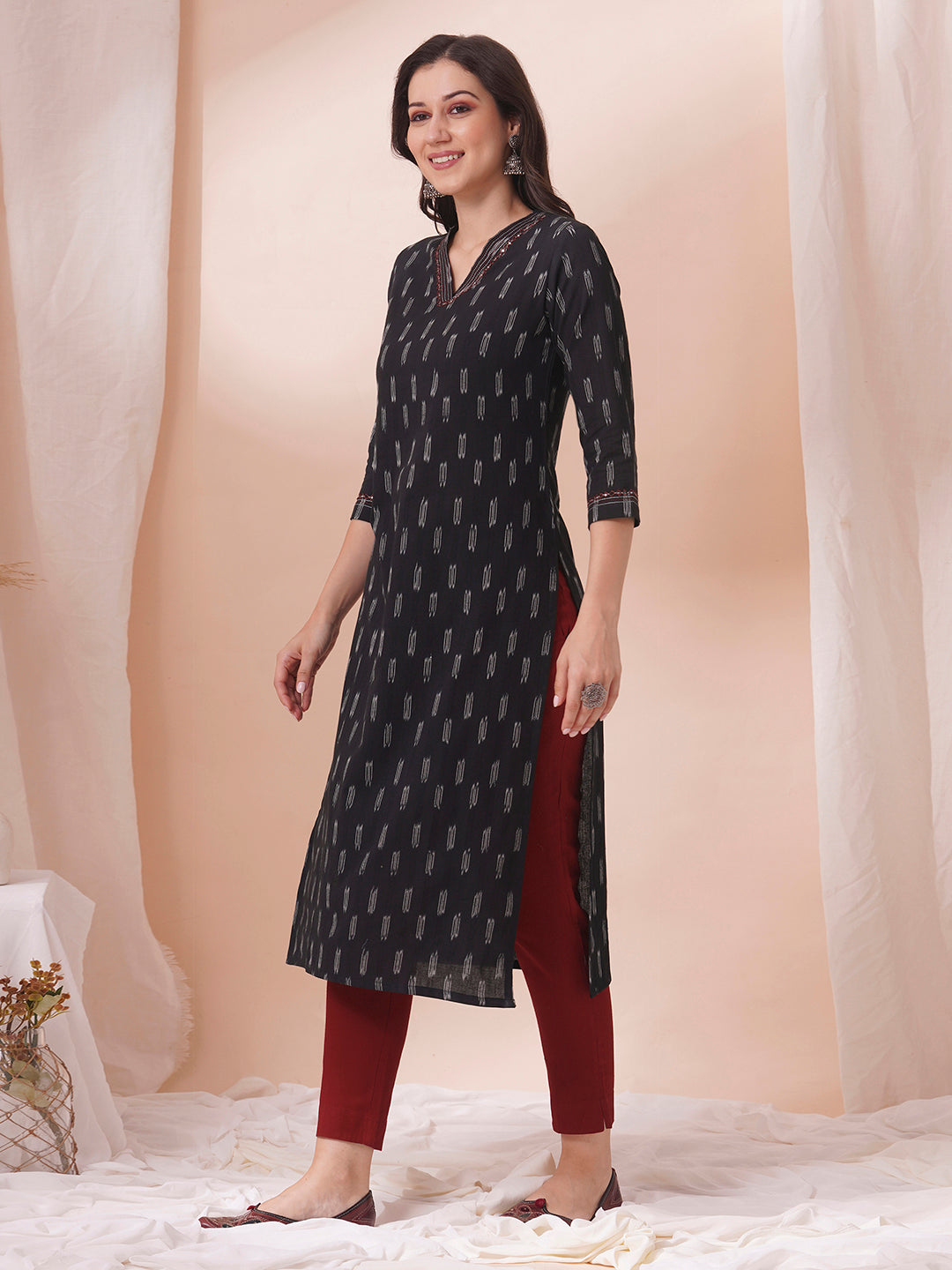 Straight fit cotton kurta in woven ikkat fabric with stitch lines and hand embroidery.