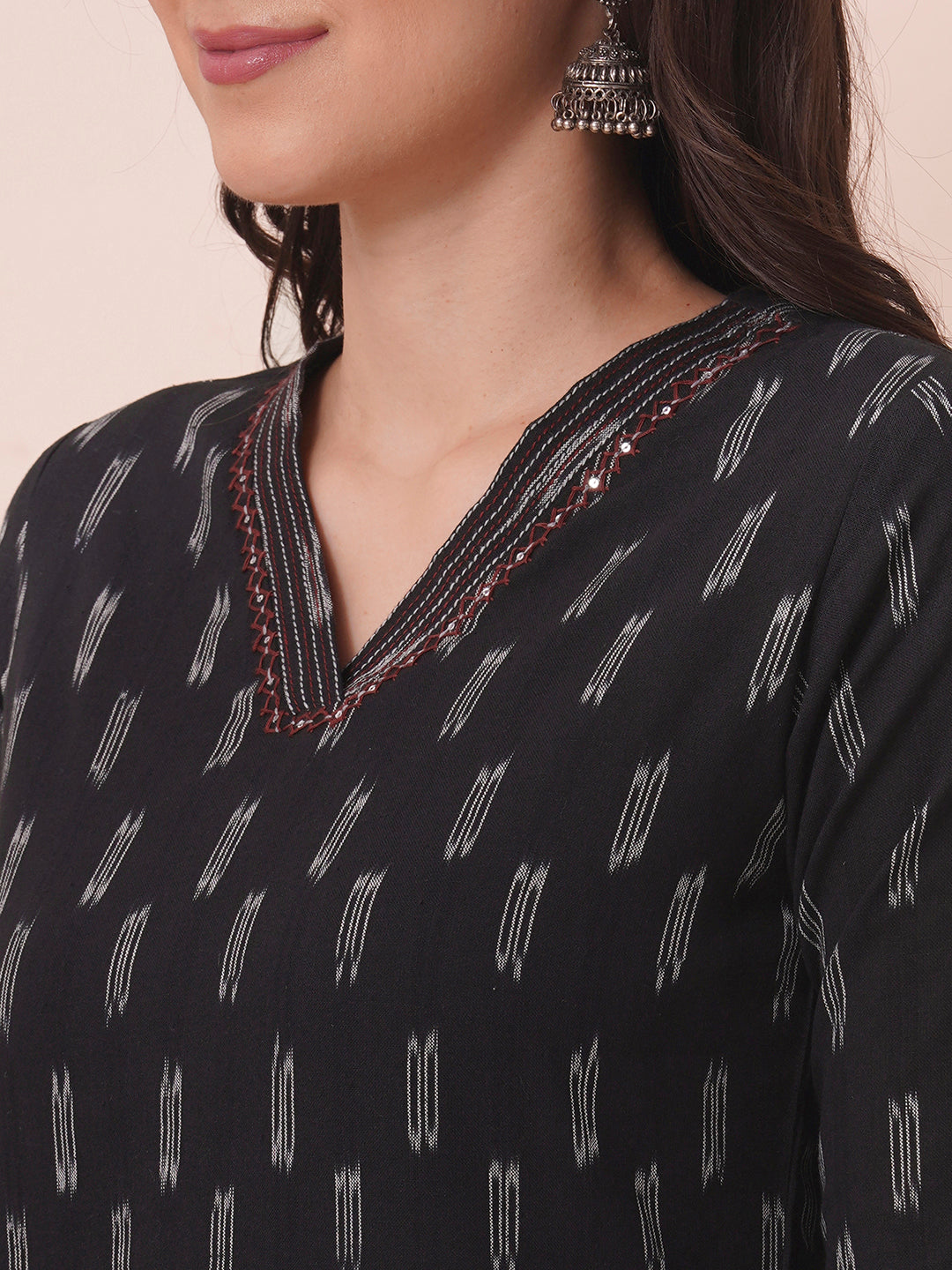 Straight fit cotton kurta in woven ikkat fabric with stitch lines and hand embroidery.