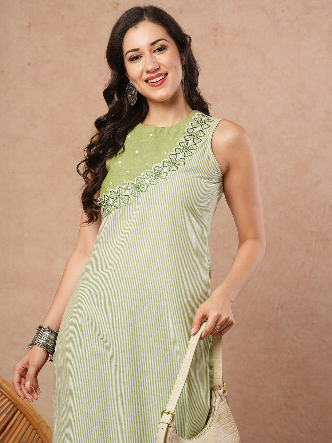 Sleeveless straight kurta with cutwork neckline and mirror work.