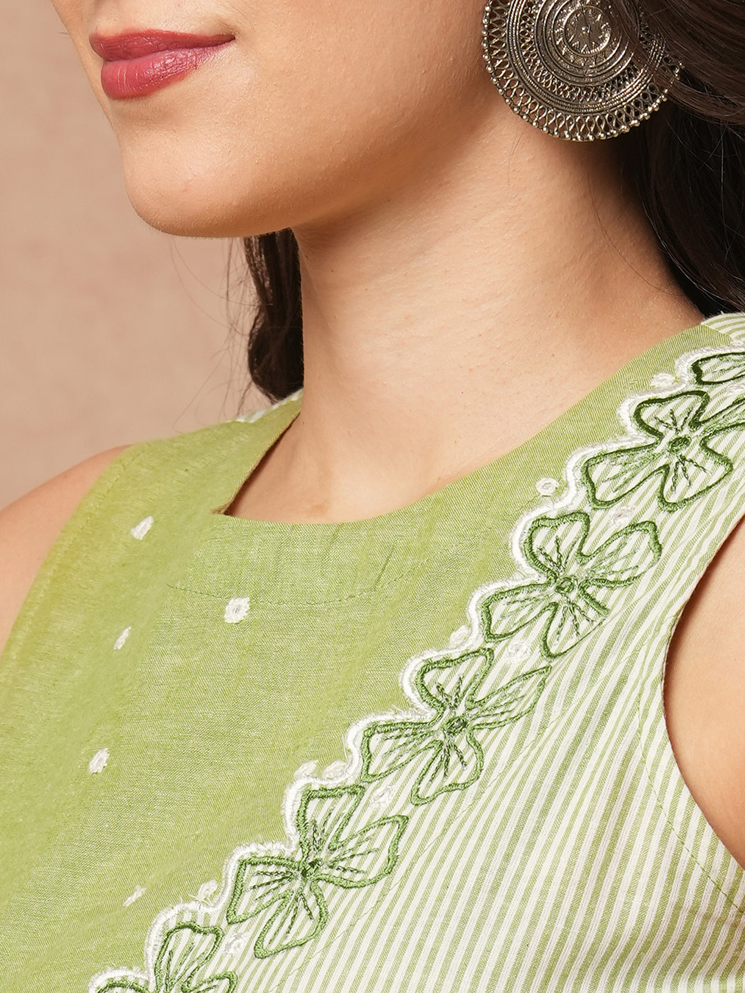 Sleeveless straight kurta with cutwork neckline and mirror work paired with palazzo.