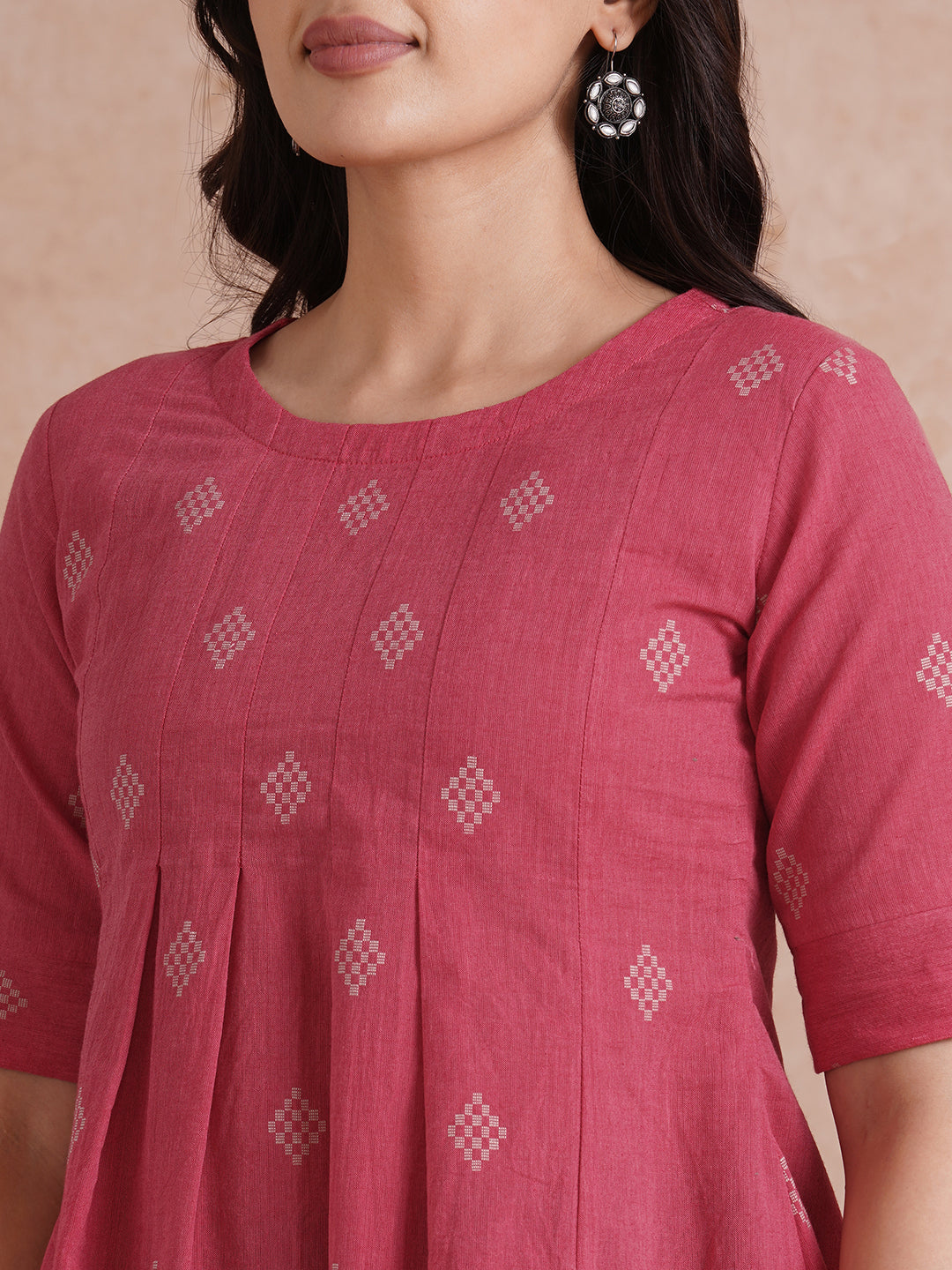 Pleated top with dobby fabric panels and elbow sleeves.