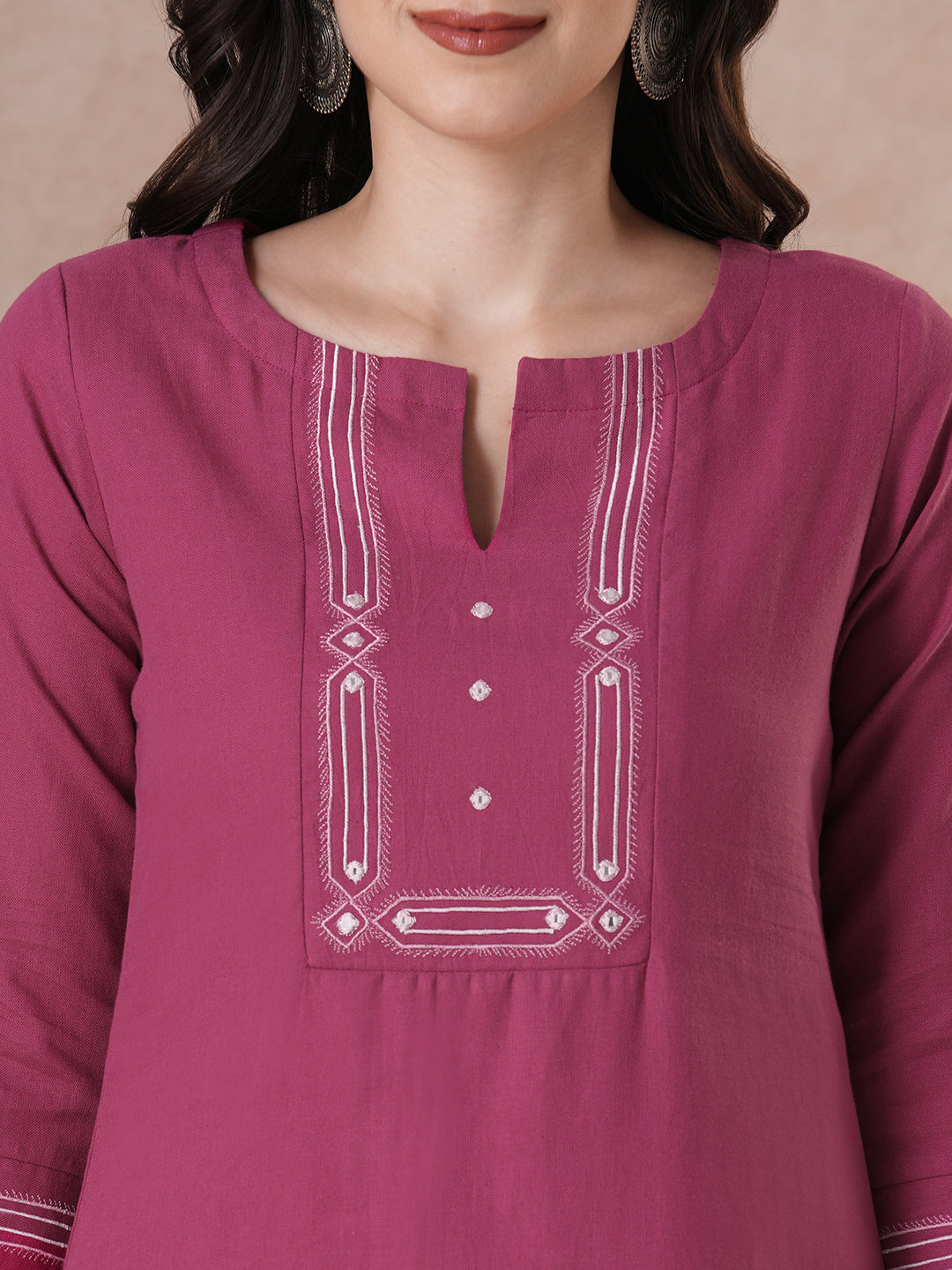 A straight fit kurta with minimal monochromatic embroidery on the neckline.