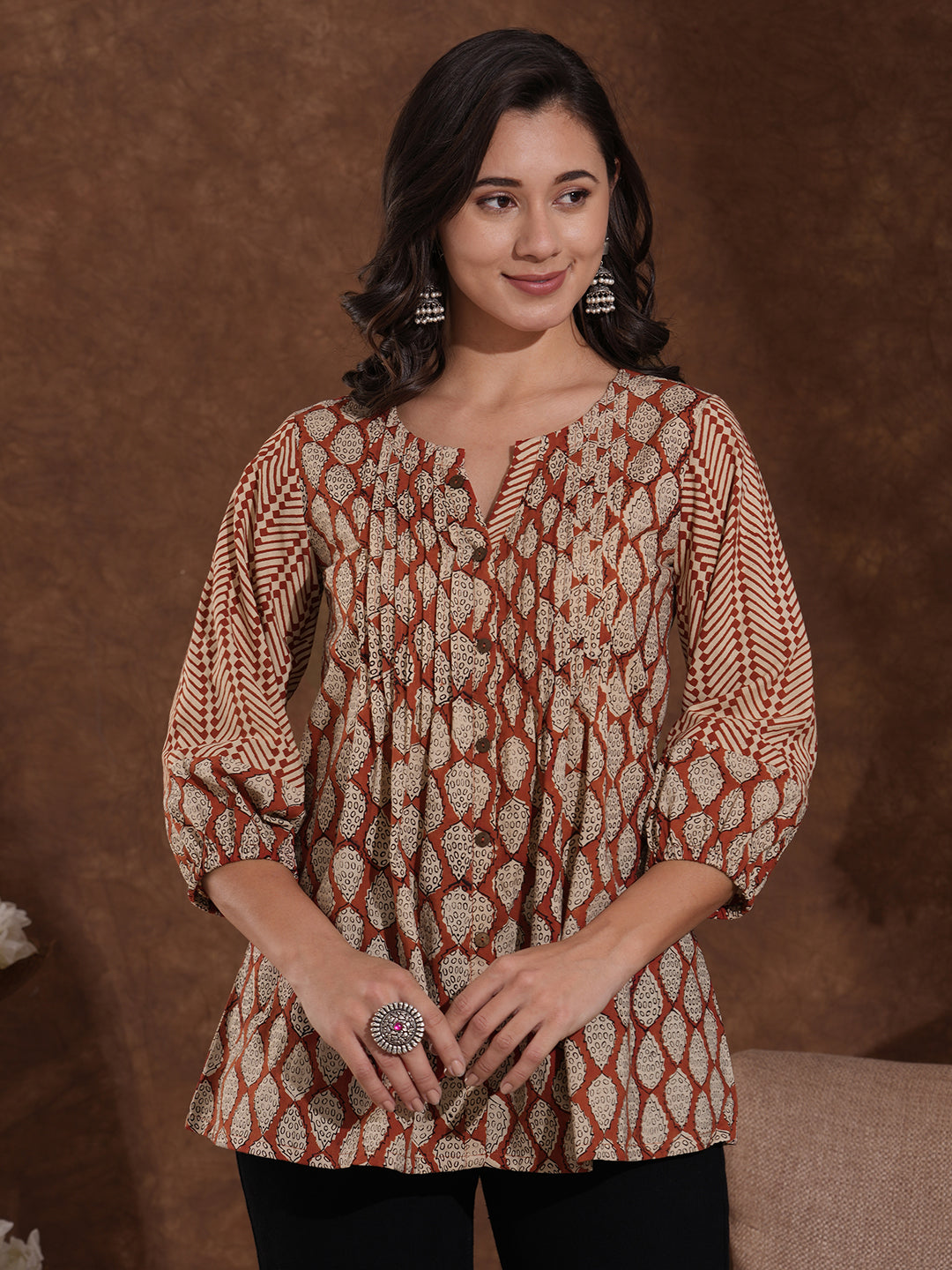 Hand block printed rust tunic with pleating and puff sleeves.