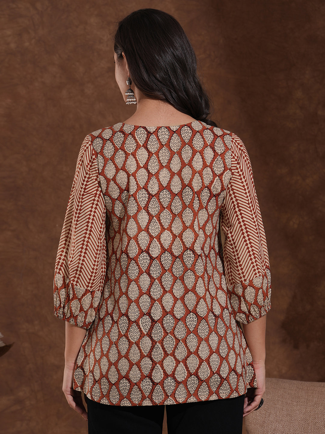 Hand block printed rust tunic with pleating and puff sleeves.