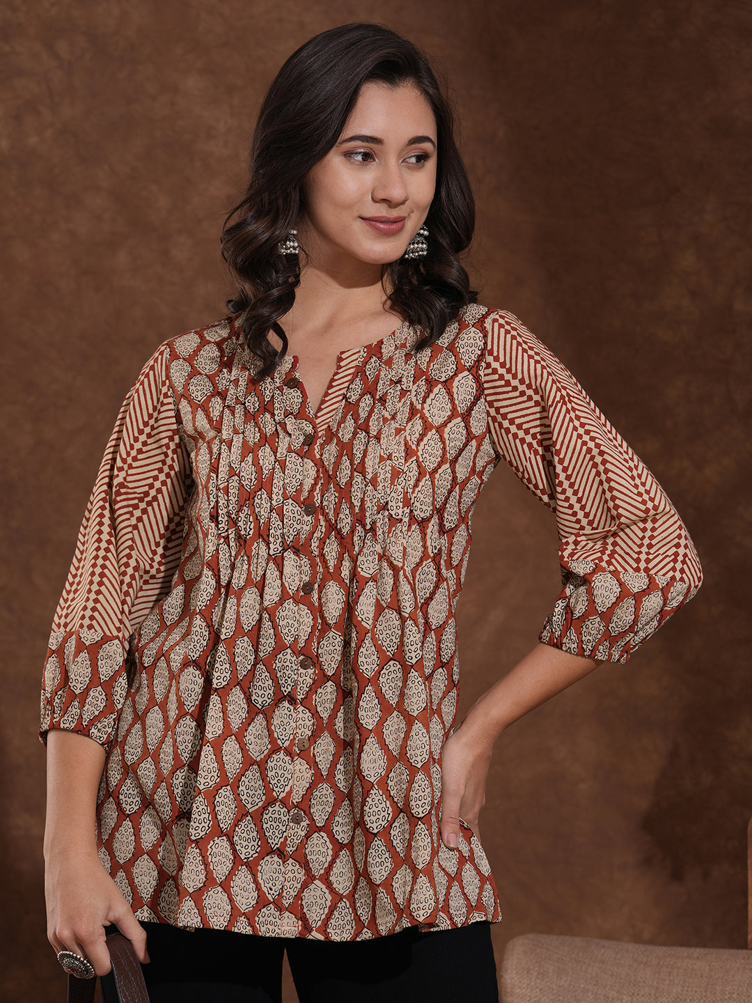 Hand block printed rust tunic with pleating and puff sleeves.