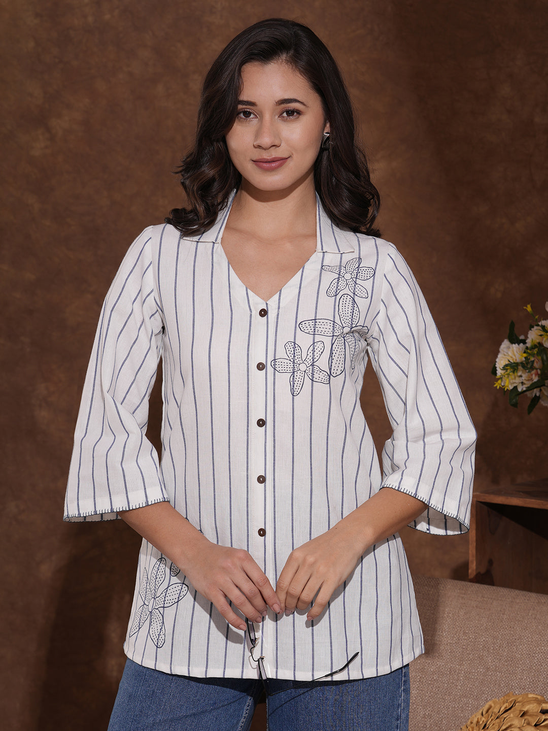 Striped top in cotton fabric with notched collar and hand embroidery.