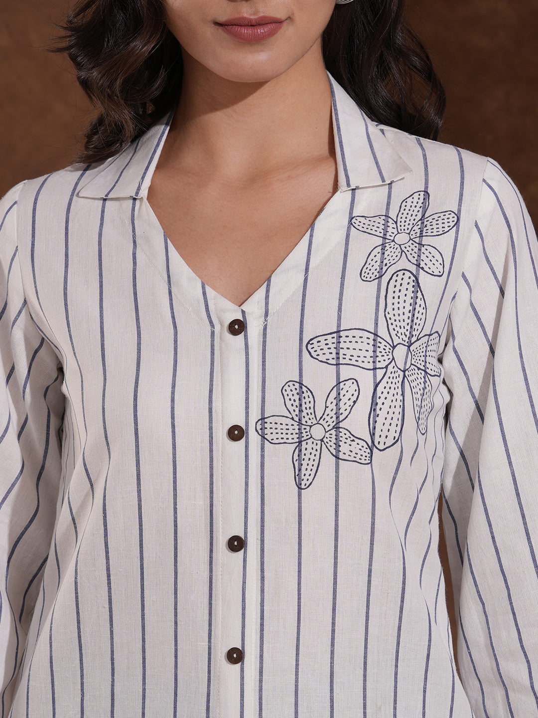 Striped top in cotton fabric with notched collar and hand embroidery.