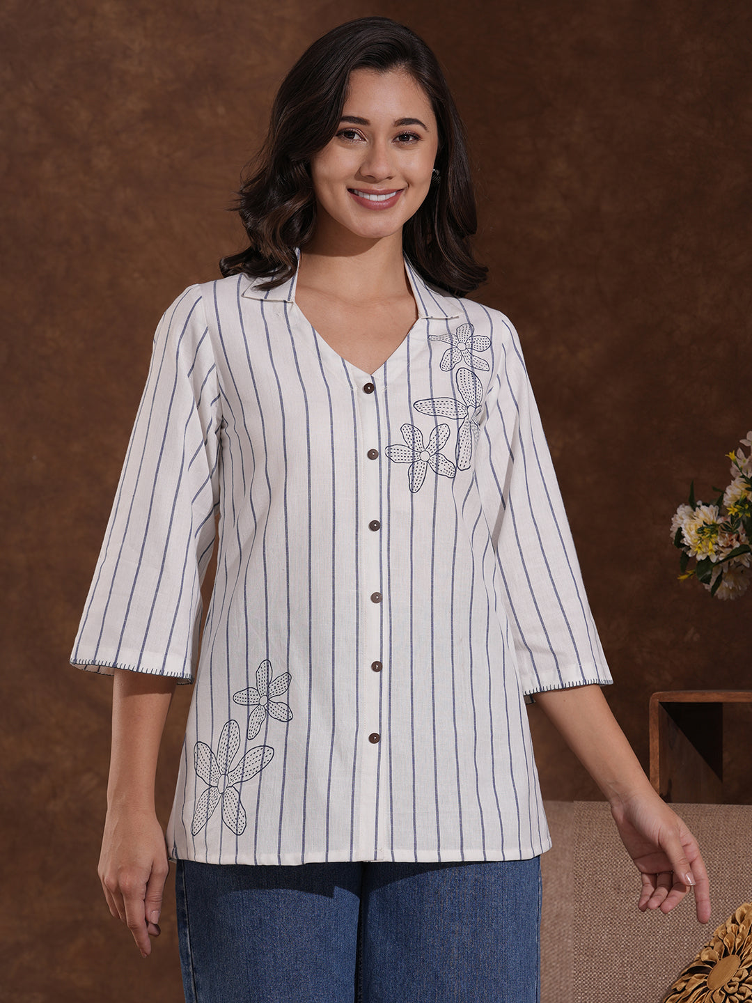 Striped top in cotton fabric with notched collar and hand embroidery.