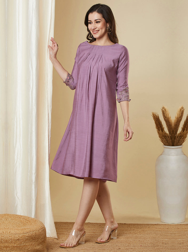 Pocketed silk blend dress with box pleating and thread embroidery.