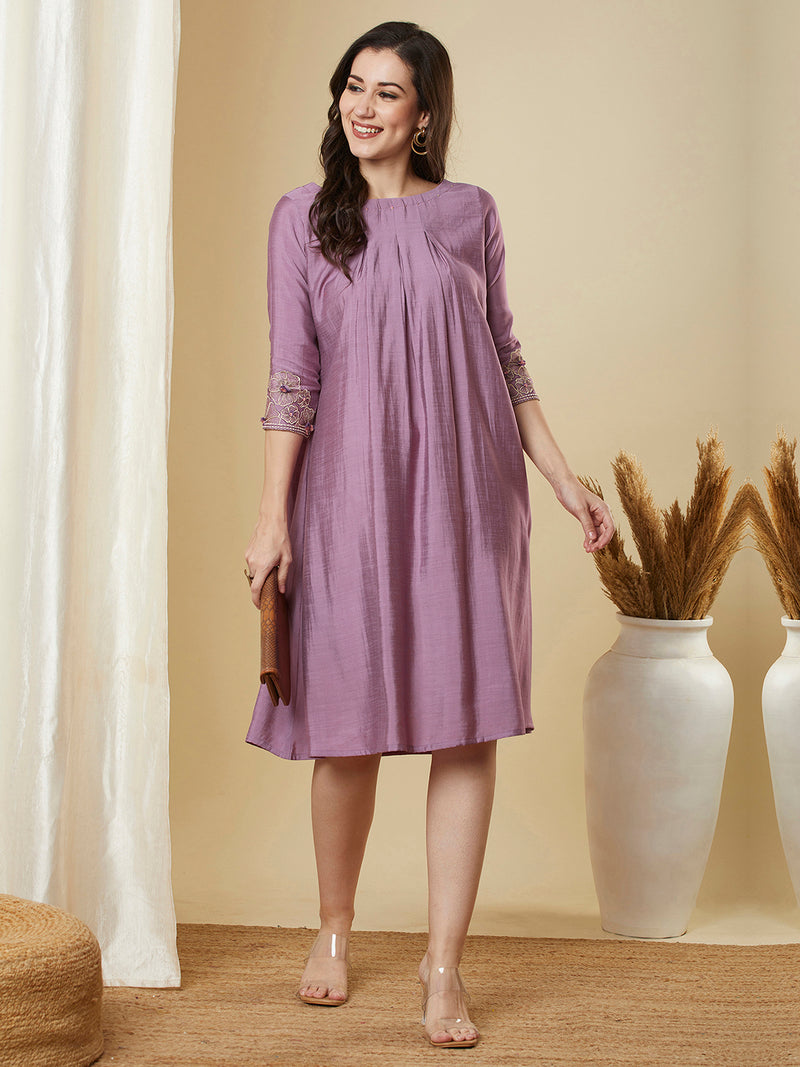 Pocketed silk blend dress with box pleating and thread embroidery.