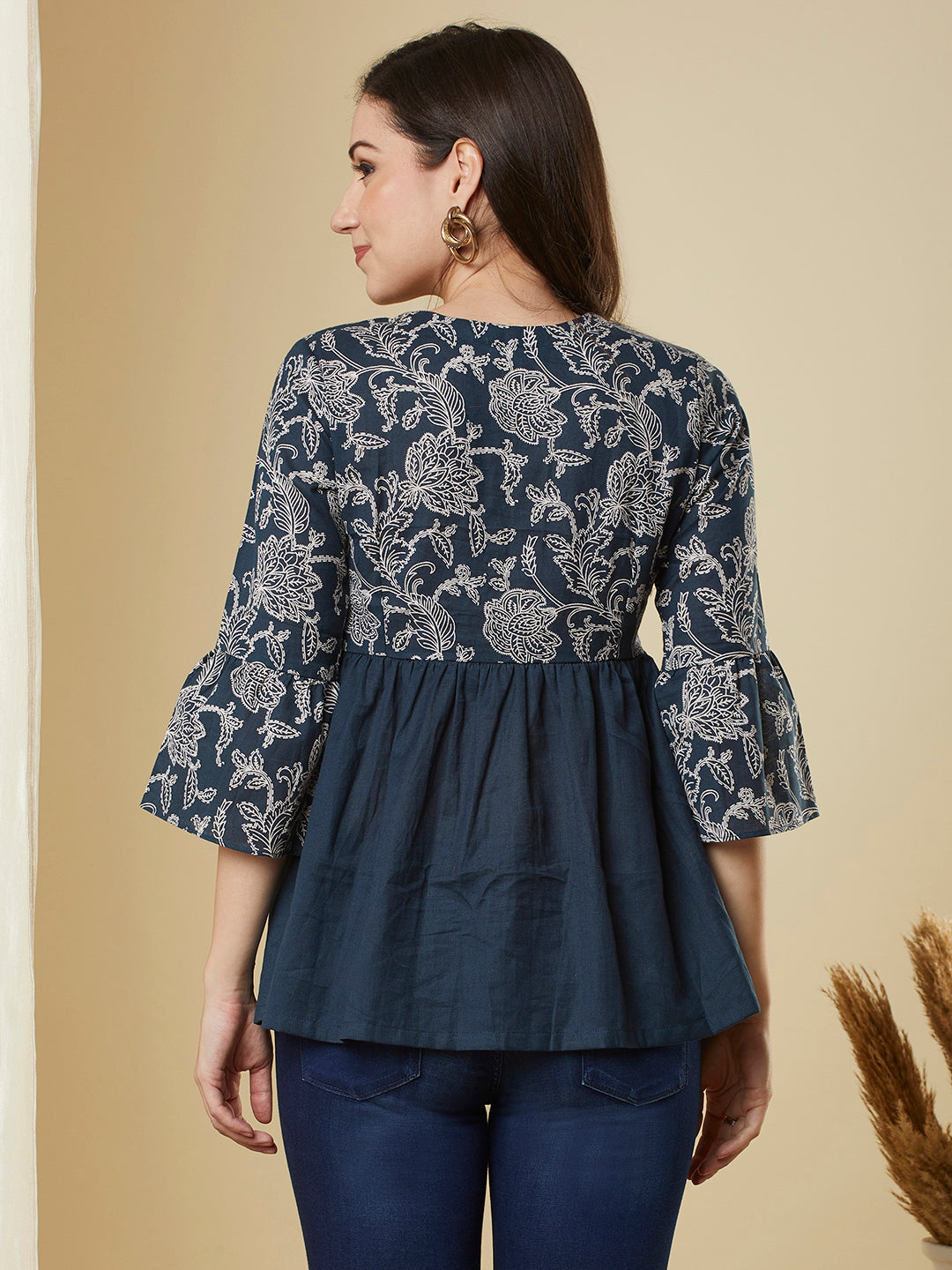 A navy blue shaped waist top with printed yoke and bell sleeves and gathered solid flare