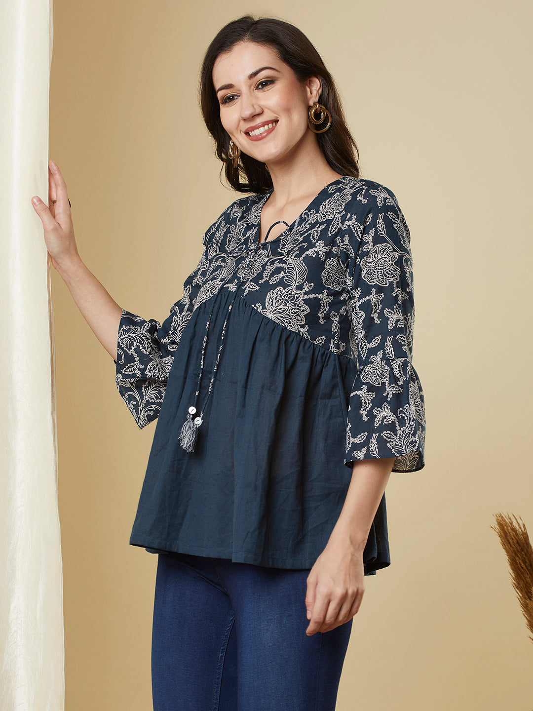 A navy blue shaped waist top with printed yoke and bell sleeves and gathered solid flare