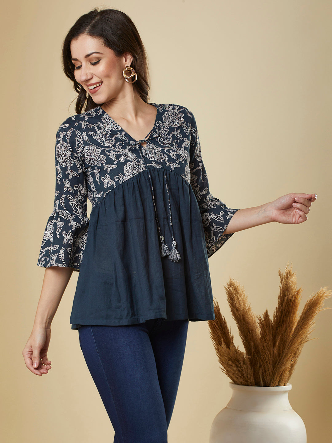 A navy blue shaped waist top with printed yoke and bell sleeves and gathered solid flare
