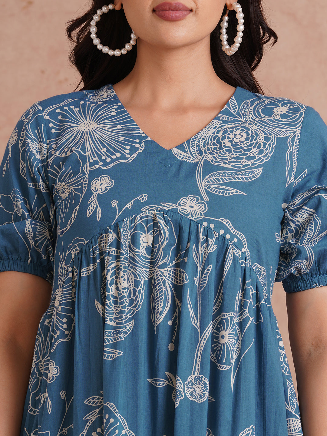Tiered dress in printed cotton with an attached in seam pocket and puffed sleeves.