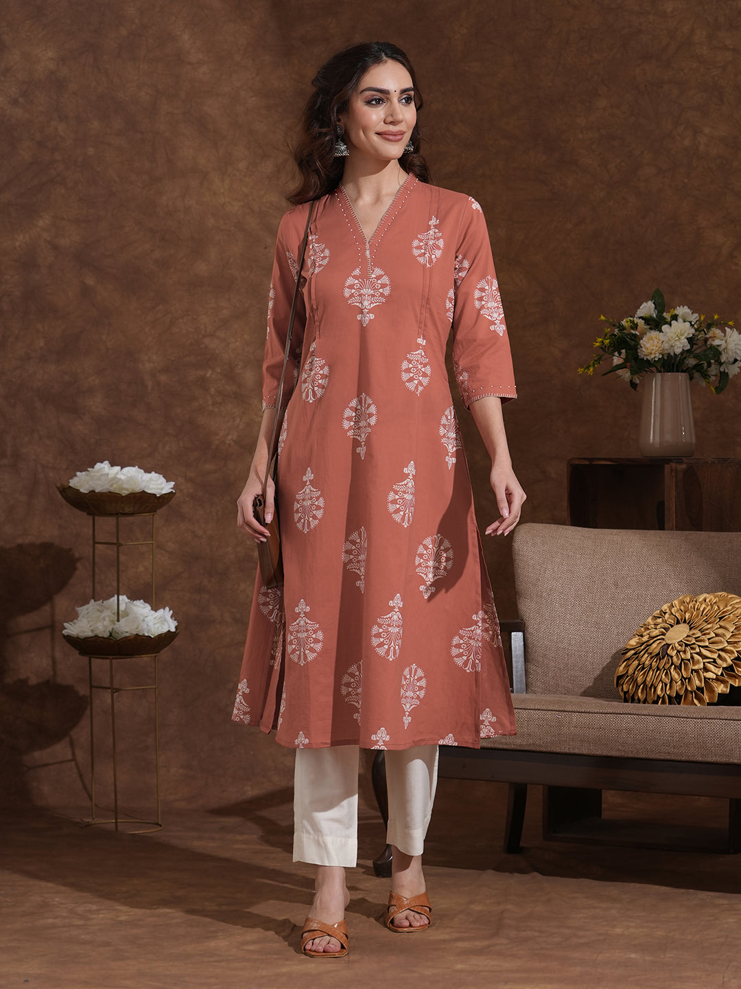 A-line cotton print kurta in rust orange color with beadwork and pocket.