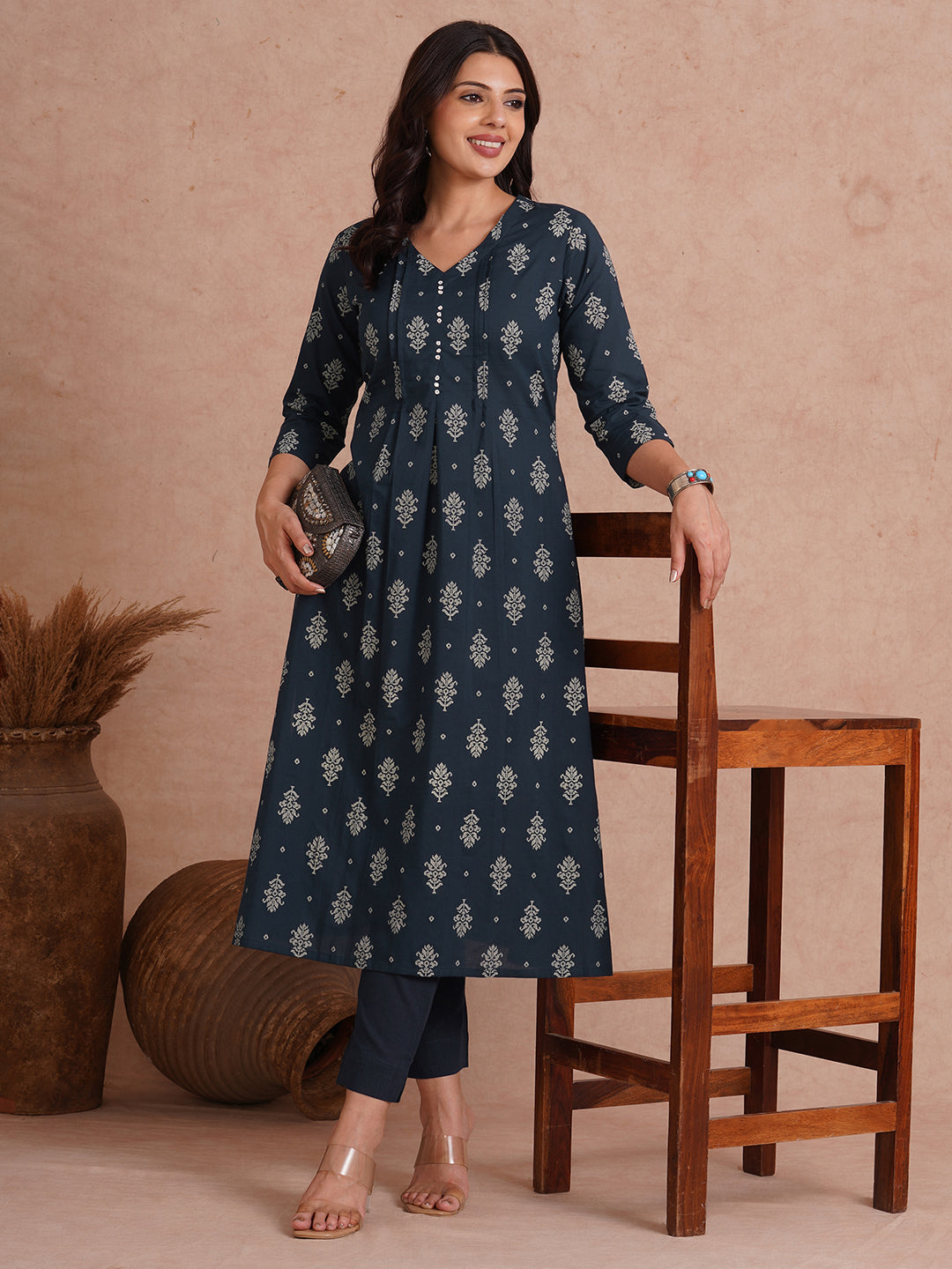 A-line kurta with tucks and box pleat in the front highlighted with handwork mirrors.