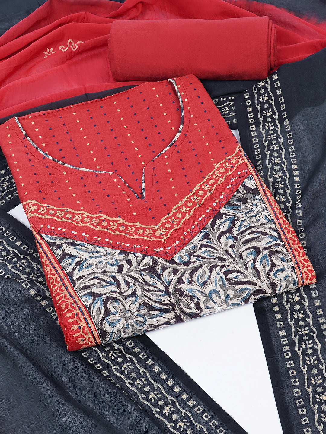 Unstitched suit set crafted in dobby fabric features a handcrafted Kalamkari printed patch.