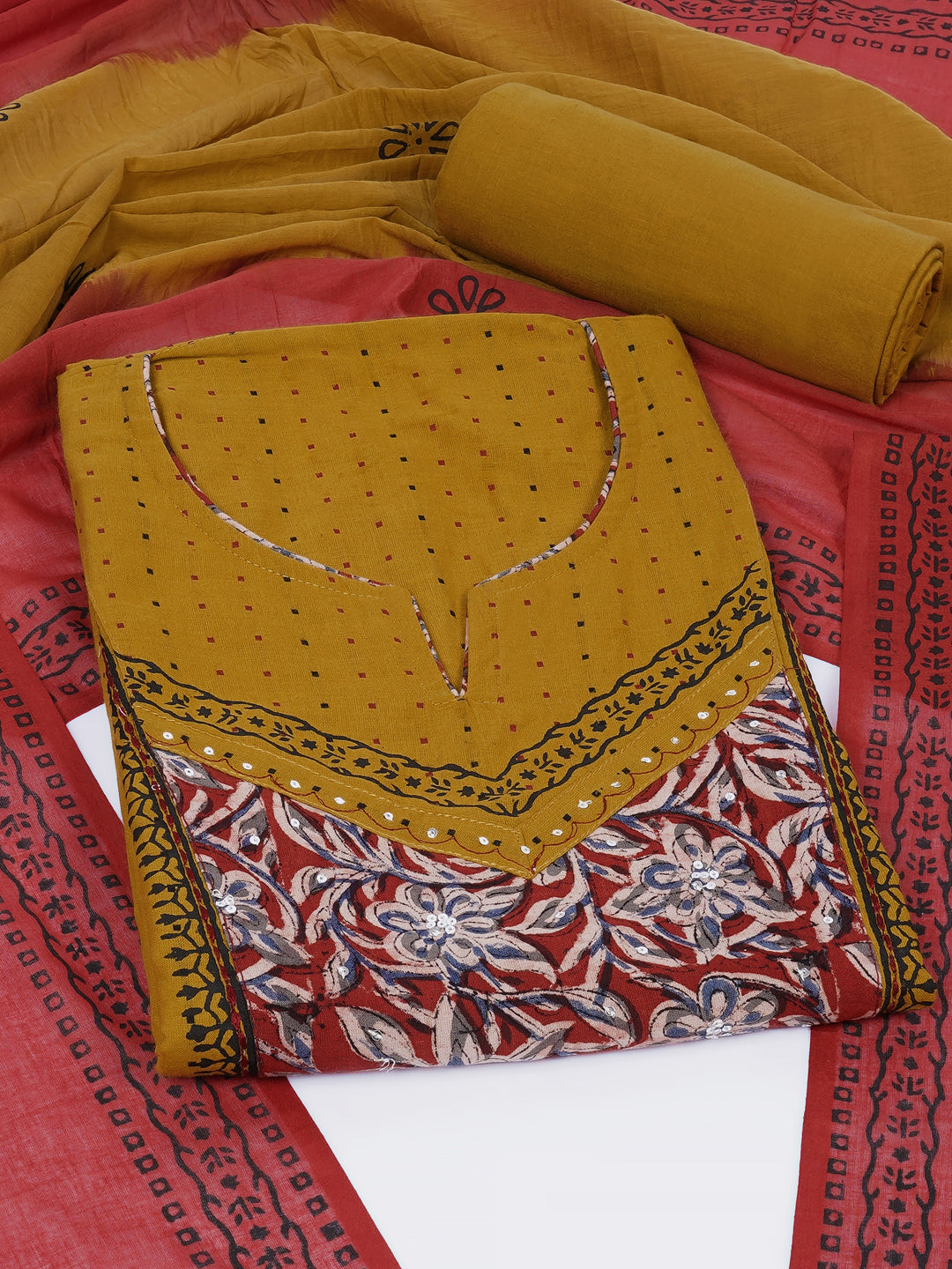Unstitched suit set crafted in dobby fabric features a handcrafted Kalamkari printed patch.