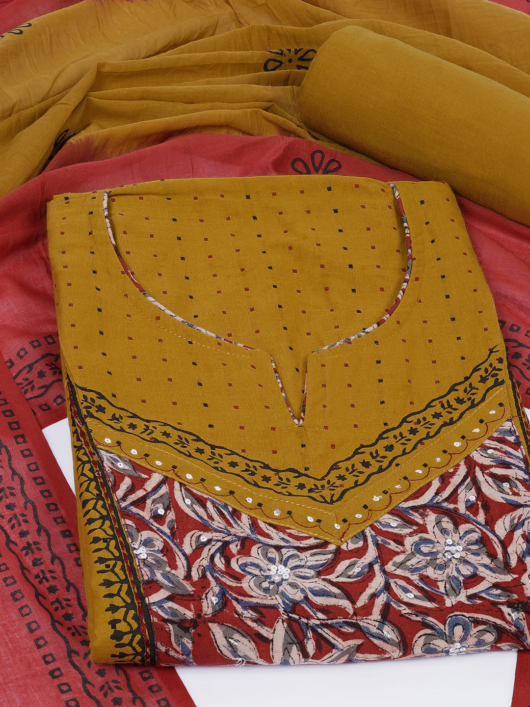 Unstitched suit set crafted in dobby fabric features a handcrafted Kalamkari printed patch.